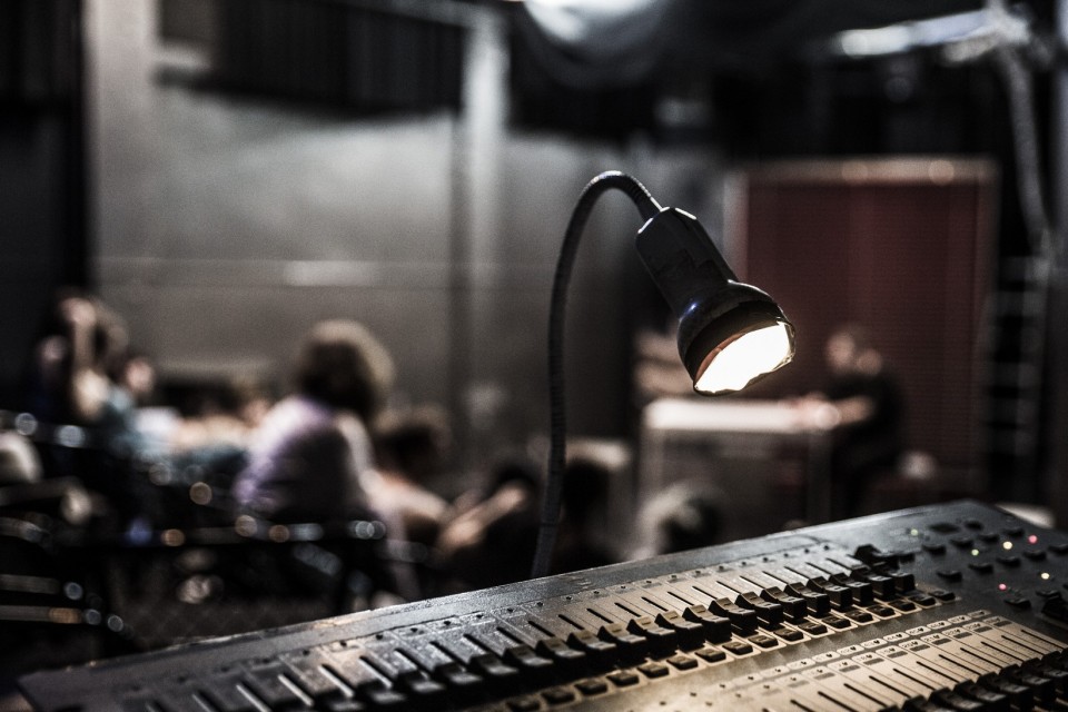 Μία κονσόλα ήχου και στο φόντο σπουδαστές θεάτρου